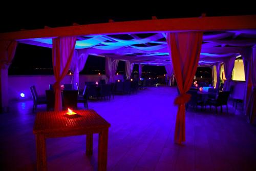 玛丽纳锡巴里BV白鹭度假酒店的一间设有桌子的房间和一间带紫色灯的房间