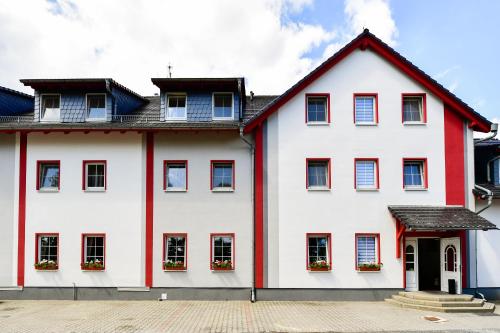 韦尔本Hotel Zum Stern Spreewald的白色的房子,有红色的修剪和窗户