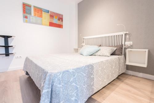 穆尔西亚Apartamento Galicia的一间卧室配有一张带蓝白色毯子的床