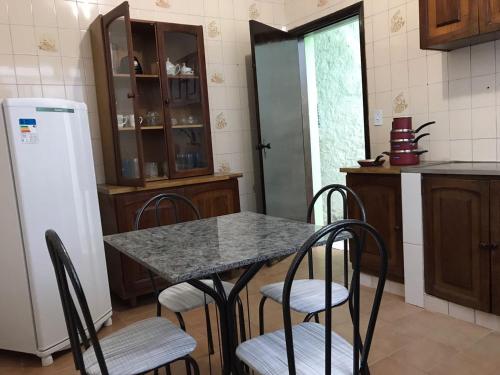 阿帕雷西达Pousada Coração de Jesus的厨房配有桌椅和冰箱。