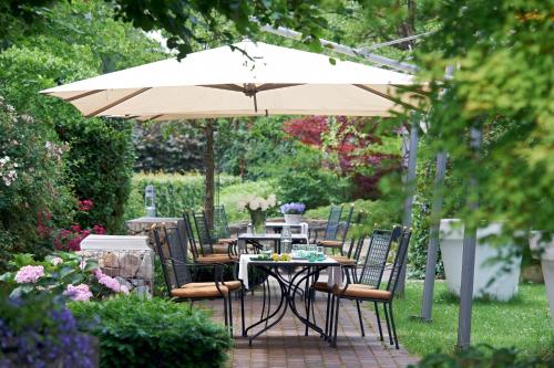 埃森敏特洛普斯布尔加腾多夫乡村酒店的花园的遮阳伞下的桌椅