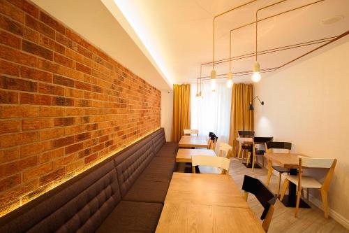 雅西塞拉米卡酒店的餐厅设有木桌和砖墙