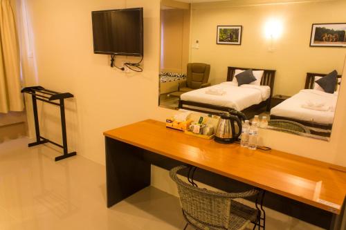 甲米镇班恩泰爱泰甲米公寓的酒店客房设有书桌,卧室配有两张床。
