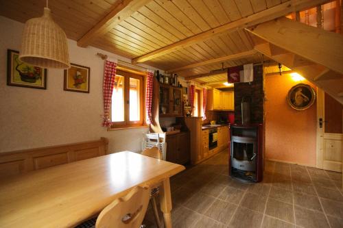 佐尔尼耶戈迪Cosy Chalet on Pokljuka - Brunarica Tinkara的厨房配有木桌和炉灶。