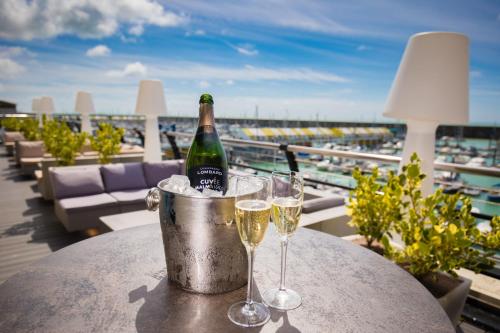 布莱顿霍夫布莱顿马尔马逊酒店的一瓶香槟和一张桌子上的两杯酒