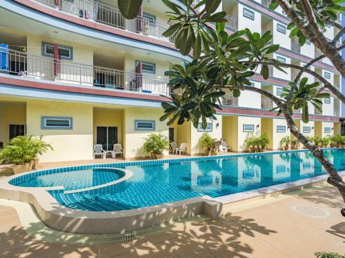 拉威海滩微笑酒店的一座树木繁茂的酒店庭院内的游泳池