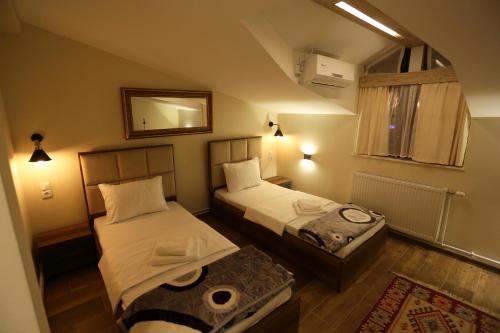 普里兹伦Saray Hotel的小房间设有两张床和镜子