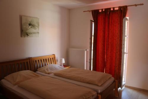 埃尔丁Gersthof的一间卧室配有床和红色窗帘