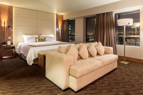 圣地亚哥圣地亚哥富豪太平洋大酒店的大型酒店客房,配有床和沙发