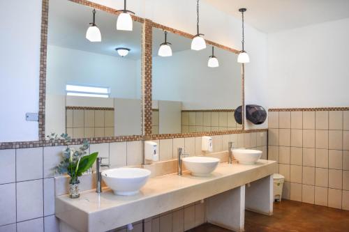 San José PinulaHotel y Resort Quinta del Sol的一间带三个水槽和大镜子的浴室