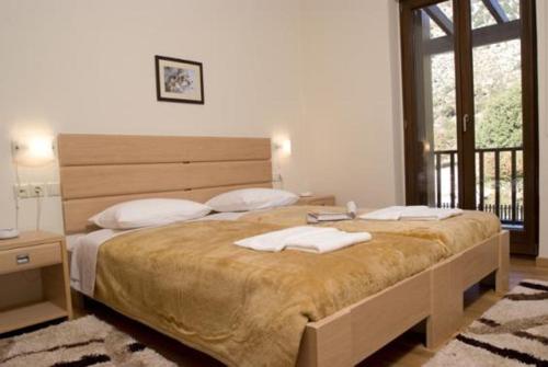 奥马洛斯撒马利亚乡村别墅的一间卧室设有一张大床和一个大窗户