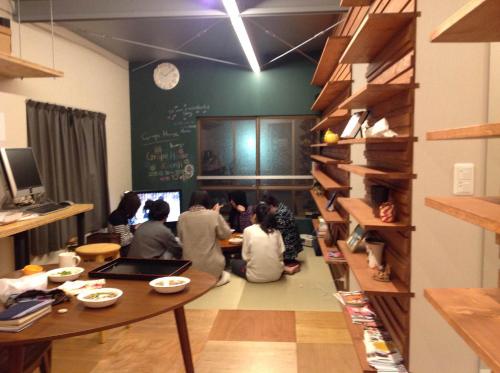 东京葡萄屋高圆寺旅舍的一群人坐在一个房间里桌子上