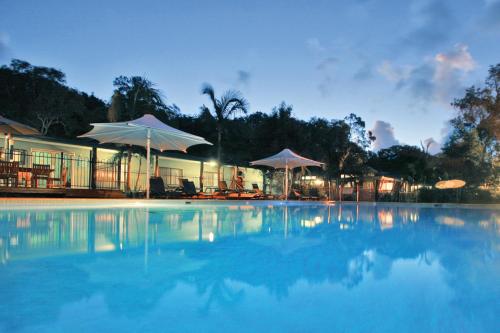 扬巴安格瑞度假酒店的大楼前带遮阳伞的大型游泳池