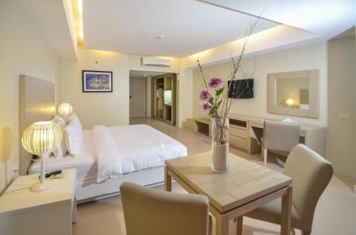 长滩岛缪斯酒店的一间卧室配有一张床和一张桌子及椅子