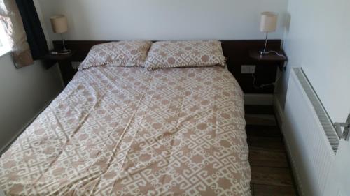 法尔卡拉Noirin's Holiday Homes的一间卧室配有一张带被子和两个枕头的床