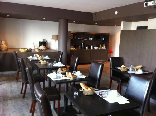 圣迪耶地球酒店酒吧的一间餐厅配有桌椅,提供食物