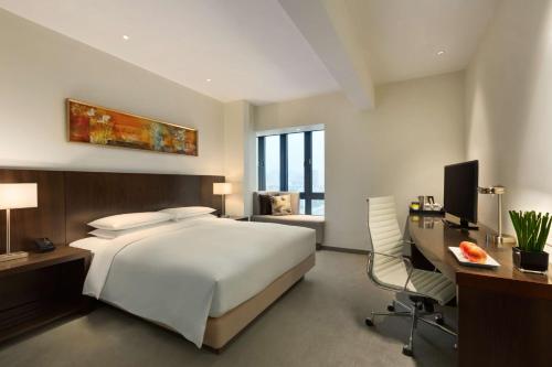 深圳深圳东门凯悦嘉轩酒店的卧室配有白色的床、书桌和椅子