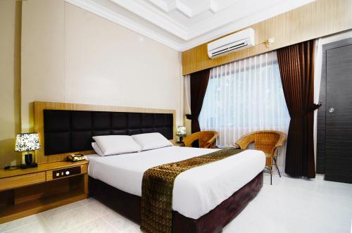 丹戎槟榔彩虹度假酒店的酒店客房设有一张大床和一张书桌。