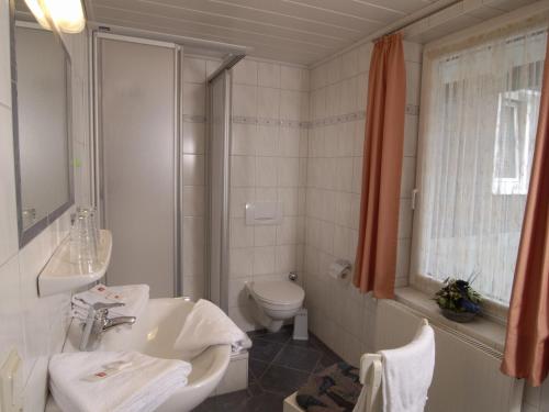 伦讷施塔特格斯特雷希旅馆的白色的浴室设有水槽和卫生间。
