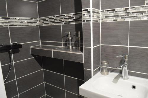 尚特皮Studio Galerie的浴室设有白色水槽和黑色瓷砖