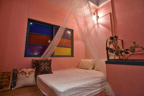 台南Green House的一间卧室设有一张床和一个窗口