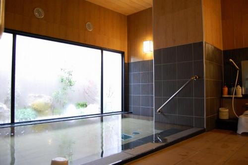 丰田市Hotel Route Inn Toyota Motomachi的带淋浴和浴缸的浴室以及窗户