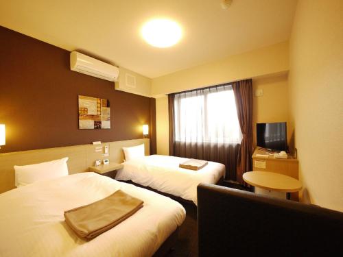 多贺城市路线宾馆 - 多贺城站东的酒店客房设有两张床和电视。