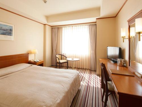 北九州小仓皇冠饭店的酒店客房配有一张床、一张书桌和一台电视。