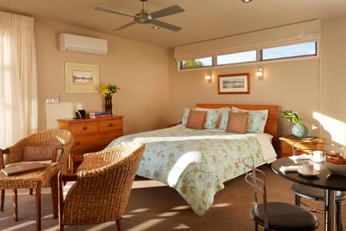 Tasman阿尔玛拉海滨山林小屋的卧室配有一张床和一张桌子及椅子