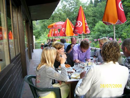 Dun-les-Places杜蒙托木屋旅馆的一群坐在餐桌上吃食物的人