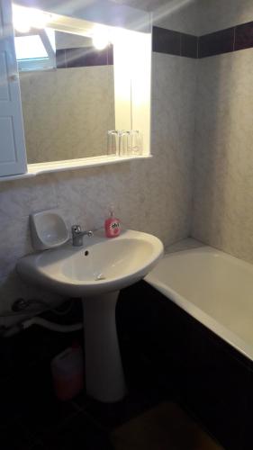 阿诺吉亚Aris Rooms的浴室配有白色水槽和浴缸。
