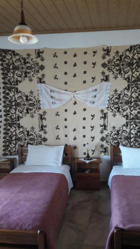 阿诺吉亚Aris Rooms的一间卧室设有两张床,墙上贴有 ⁇ 蝠。