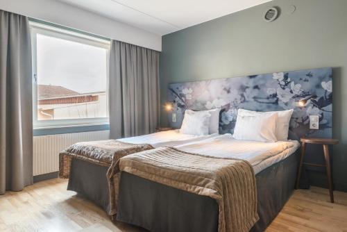 林雪平伊克森品质酒店的酒店客房设有一张蓝色墙壁的大床