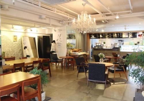 首尔设计师弘大酒店的一间带桌椅和吊灯的餐厅