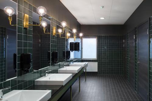 林雪平伊克森品质酒店的浴室设有3个水槽和一排镜子