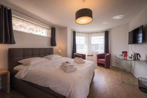 德莱蒙B+B Passifleur的卧室设有一张白色大床和一扇窗户。