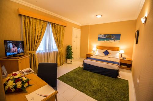 迪拜Welcome Hotel Apartments 1的配有一张床和一张书桌的酒店客房