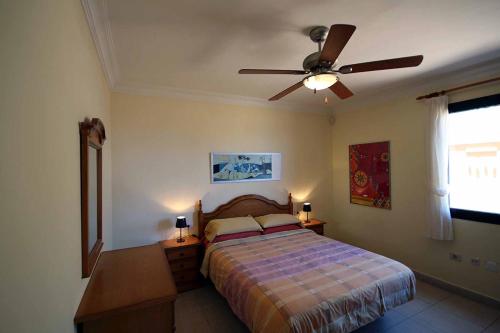 厄尔梅达诺SOTA 3 by RENTMEDANO Beach front, spectacular ocean views, parking, WiFi的一间卧室配有一张床和吊扇