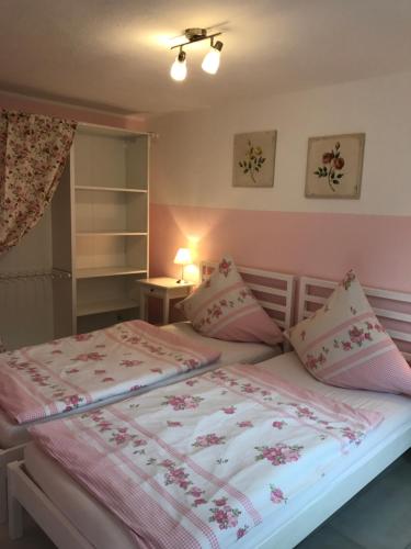 GrafrathUnterkunft für Arbeiter und Monteure的一间卧室配有一张带粉色床单和枕头的床。