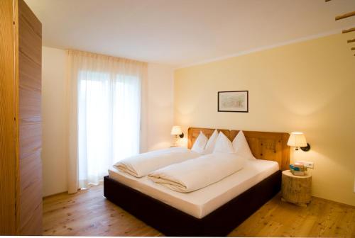普拉托·阿罗·斯泰尔维奥古斯塔夫尼公寓的一间卧室配有一张带白色床单的床和一扇窗户。