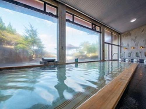 胜浦市胜浦帕尔斯酒店的大型室内游泳池,设有大窗户
