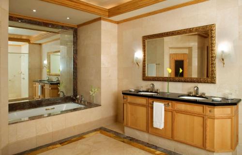 马斯喀特凯悦大酒店马斯喀特的浴室设有2个水槽、浴缸和镜子