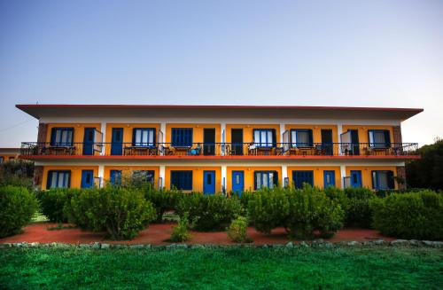 Pyrgi ThermisHotel Votsala的一座拥有蓝色和橙色门和灌木的建筑