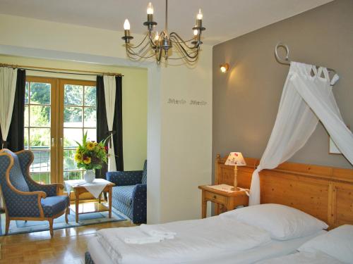 Warth斯坦恩舒乐霍夫酒店的卧室配有床、椅子和窗户。