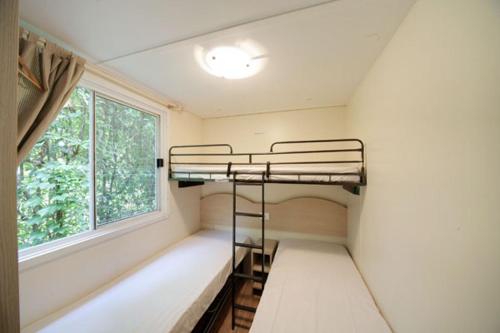 莱萨苏奇露营酒店的客房设有两张双层床和一扇窗户。