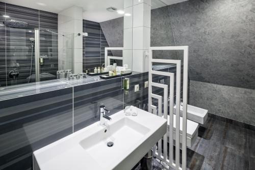 谢维日自然商务SPA酒店的浴室配有白色水槽和淋浴。