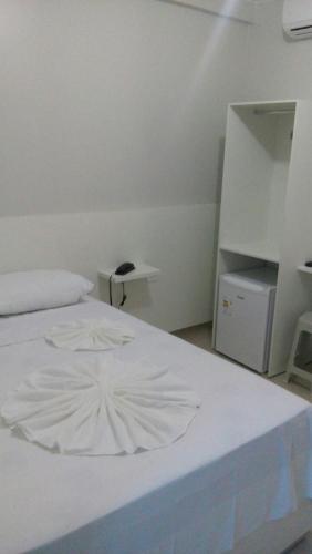 阿拉皮拉卡Hotel Confiança的卧室配有白色的床铺和白色的桌子