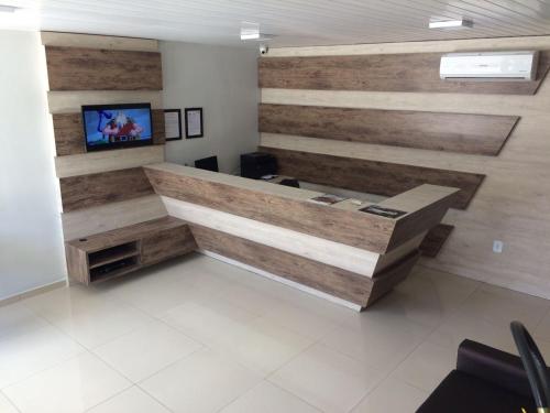 阿拉皮拉卡Hotel Confiança的办公室设有木墙和书桌