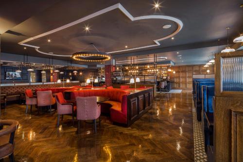都柏林都柏林摩天酒店的一间设有红色椅子的餐厅和一间酒吧