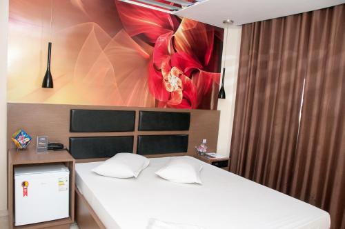 圣保罗席帕斯汽车旅馆（仅限成人）的卧室配有一张挂着红花的床。